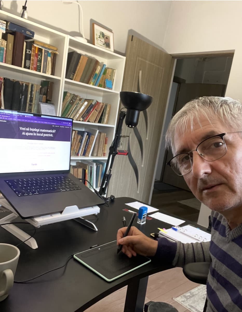Abel Cavași la birou, în fața laptopului și a tabletei grafice